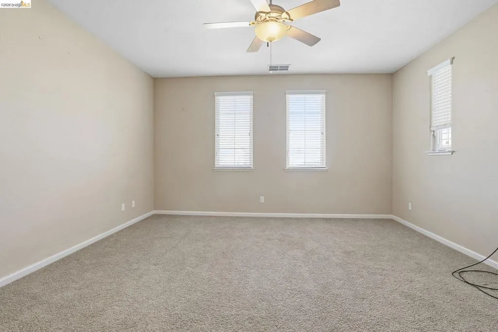 Spare room featuring ceiling fan and light carpet