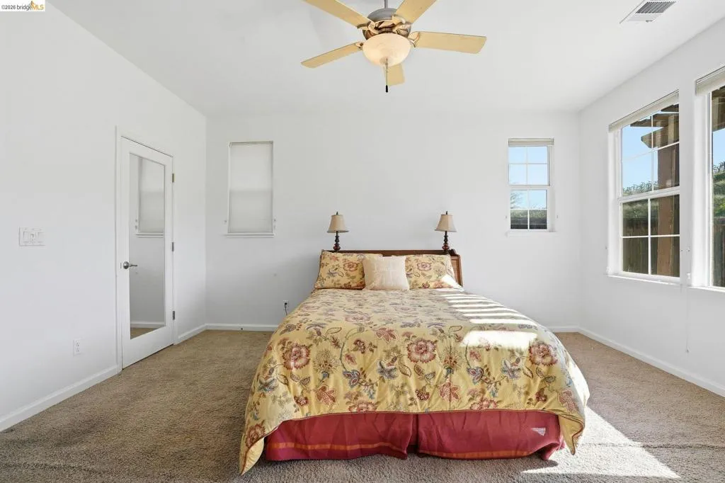 Carpeted bedroom with baseboards and ceiling fan