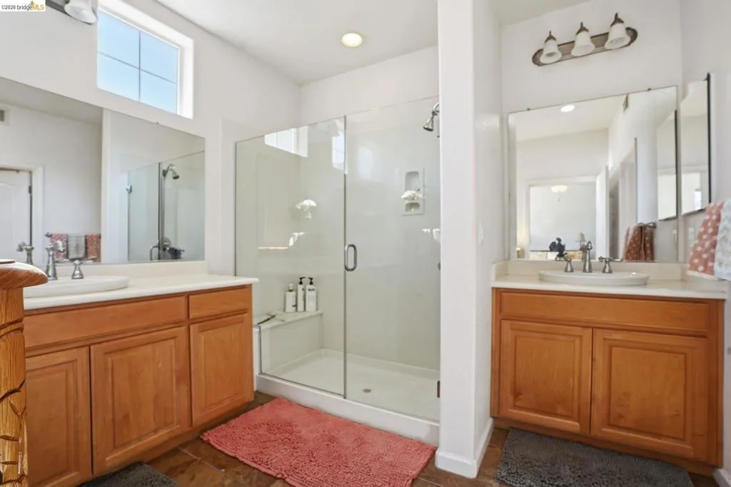 Bathroom with two vanities and a stall shower