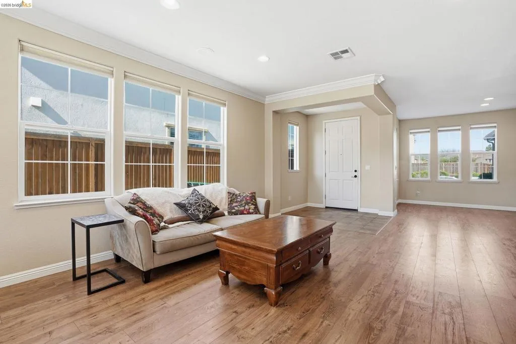 Living room featuring light wood-type flooring, recessed lighting, and ornamental molding