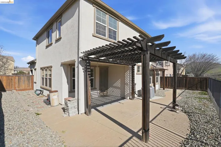 Rear view of house with a pergola, a patio, a fenced backyard, and stucco siding