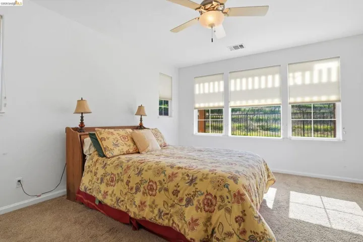 Bedroom featuring light carpet and ceiling fan