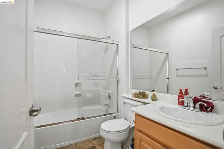 Bathroom featuring vanity and enclosed tub / shower combo