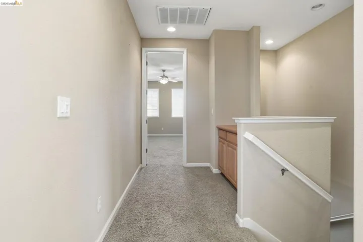 Hall featuring light colored carpet, an upstairs landing, and recessed lighting