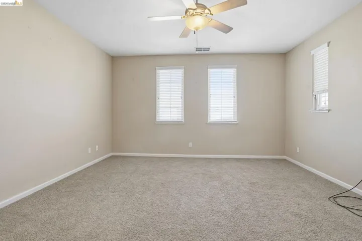 Spare room featuring ceiling fan and light carpet