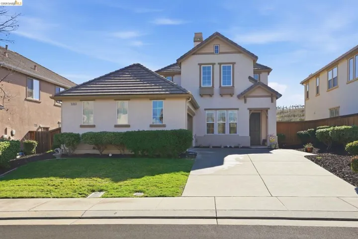 Traditional home featuring stucco siding, a chimney, and a tiled roof