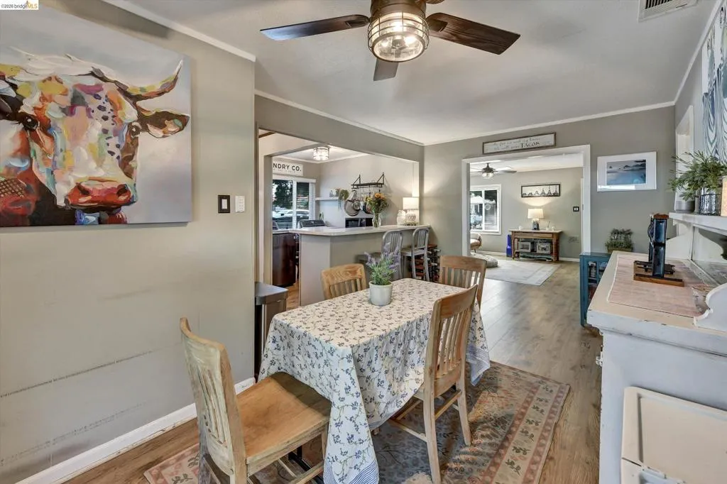 Dining area featuring wood-finish flooring and a ceiling fan with integrated lighting