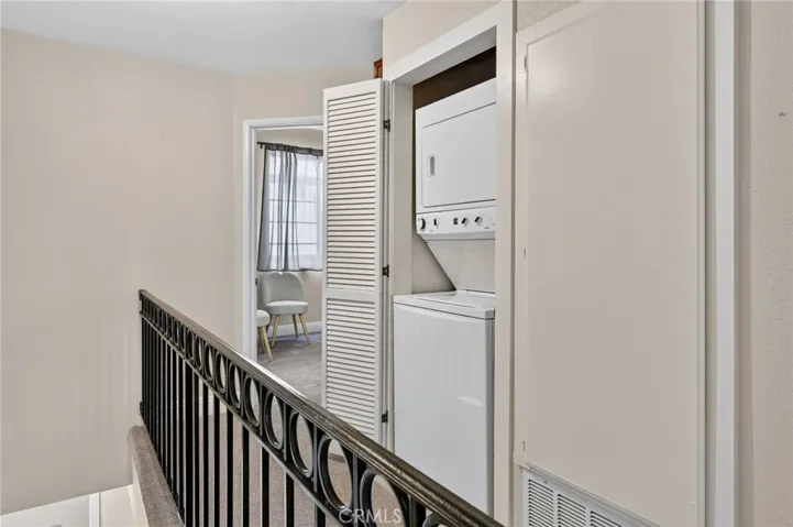 Upstairs stacked laundry unit is in a hallway closet