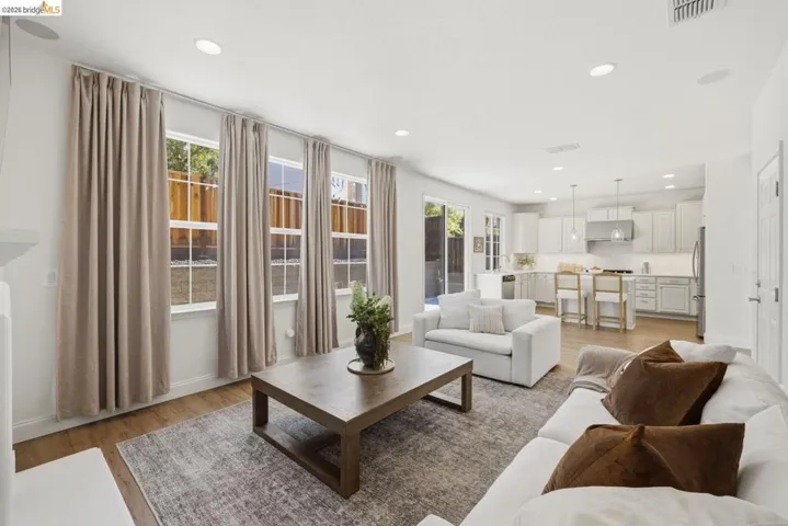 Kitchen featuring wood-finish flooring, light cabinetry, white countertops, and a full-height tile backsplash