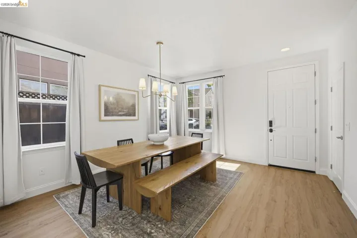 Room featuring wood-finish flooring, a window with blinds, and a built-in closet with bi-fold doors