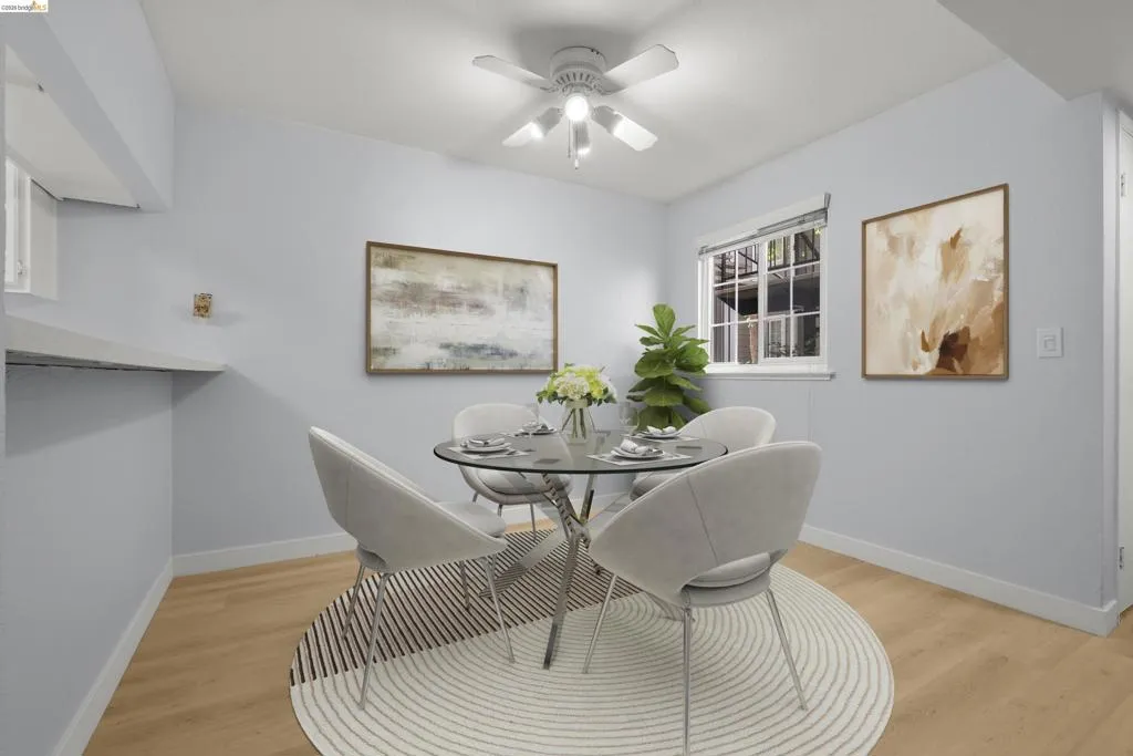 Elegant dining space featuring a round glass-top table with chrome base, paired with upholstered dining chairs