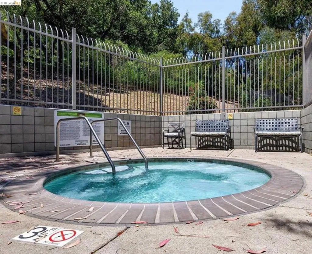 Circular spa with concrete surround and brick coping