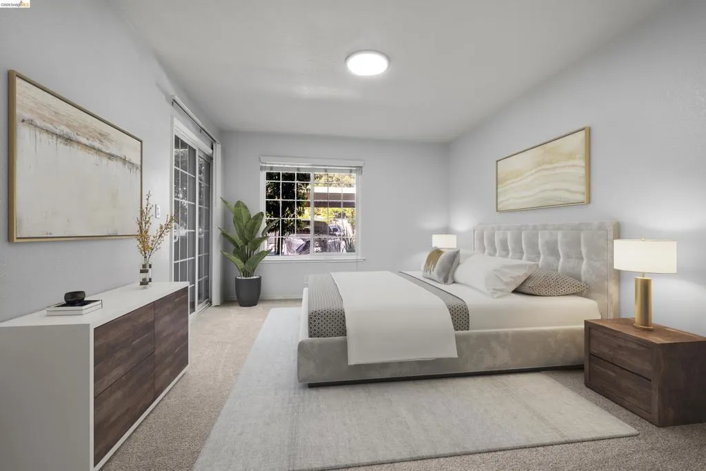 Spacious primary bedroom featuring a tufted upholstered bed frame, wood-finish nightstands with integrated lighting, neutral carpeting, and recessed ceiling lights