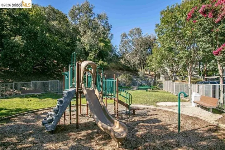 Community playground featuring multiple slides and climbing elements set on a wood chip surface