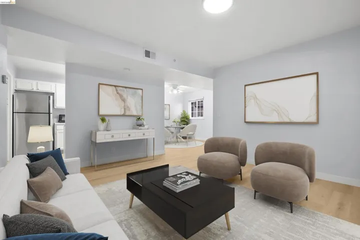 Contemporary living room showcasing light wood-finish flooring, recessed ceiling lighting, and neutral wall finishes