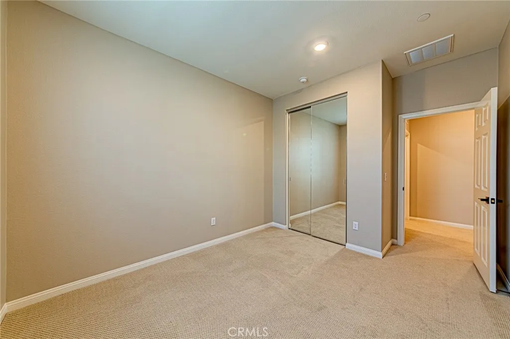 The second bedroom features custom carpeting