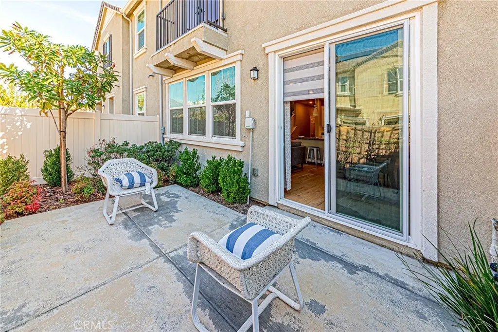 The private patio area is beautifully landscaped with mature trees and colorful flowers, complemented by a drip irrigation system for easy maintenance