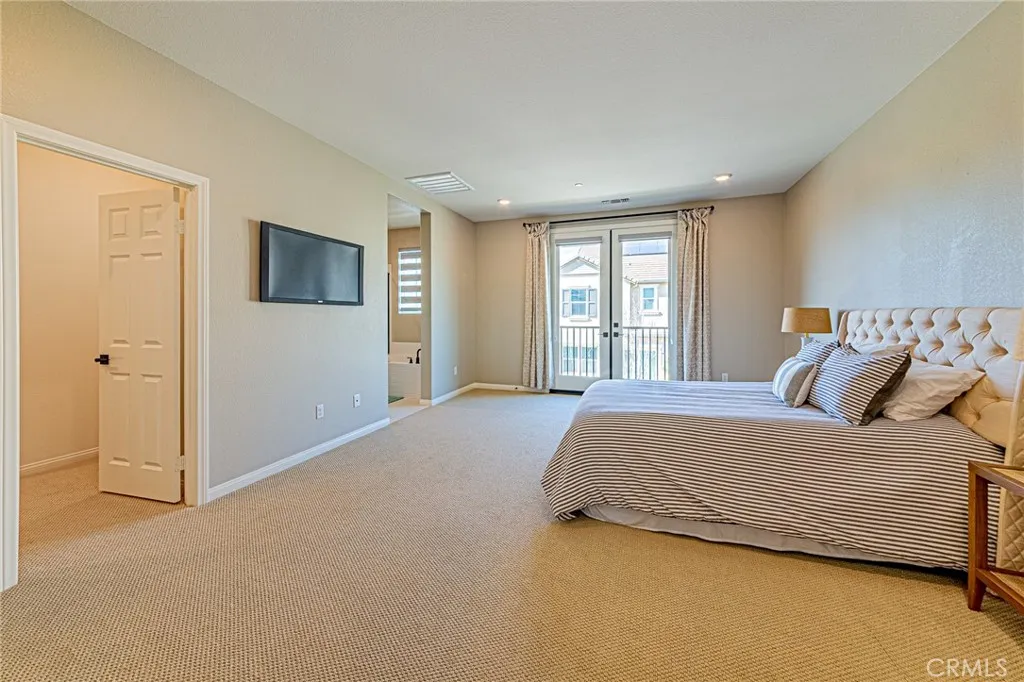 The spacious primary suite features an elegant double-door entry and a charming Juliet balcony