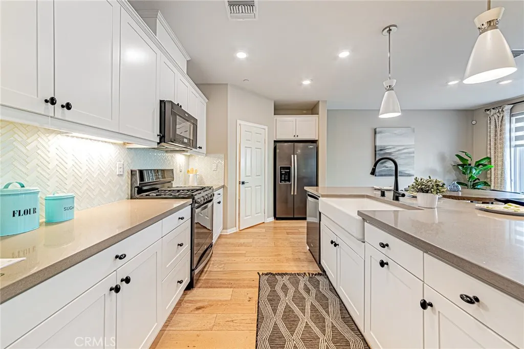 The gourmet kitchen showcases a designer custom backsplash, top-quality stainless steel appliances, and a premium refrigerator, all included with the home