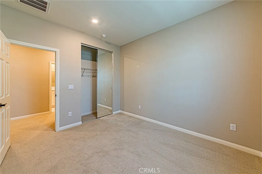The third bedroom features custom carpeting and stylish window shades
