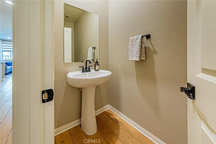Half bathroom is conveniently located near the entry area and features elegant wood flooring