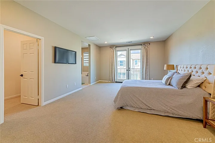 The spacious primary suite features an elegant double-door entry and a charming Juliet balcony