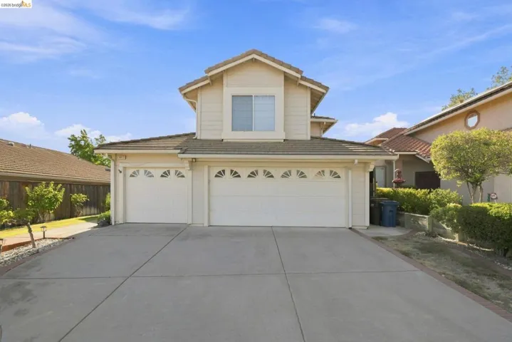 Two-story exterior with a two-car garage, concrete driveway, and a tiled roof