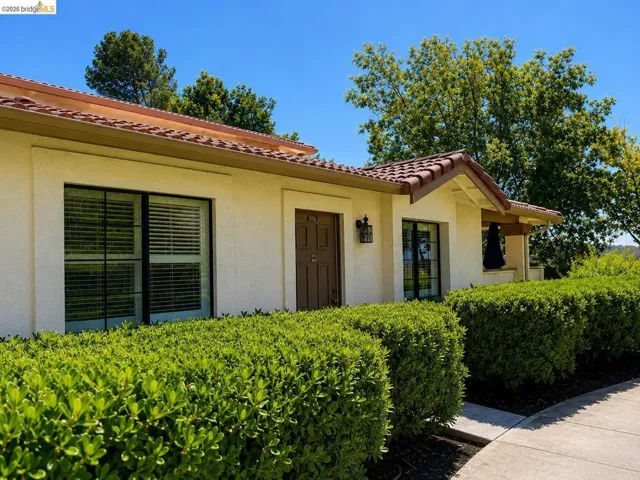 Mediterranean-inspired facade featuring a tile roof and light-colored stucco exterior.