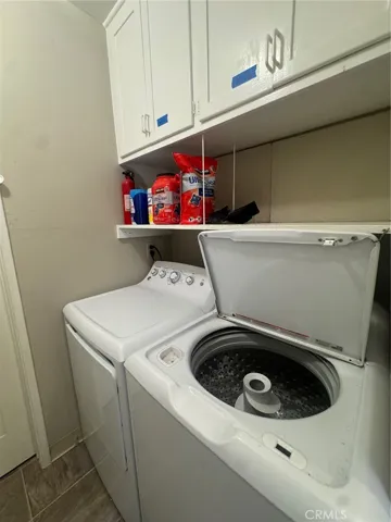 Shared laundry room with the front unit offers additional storage cabinets for added convenience.