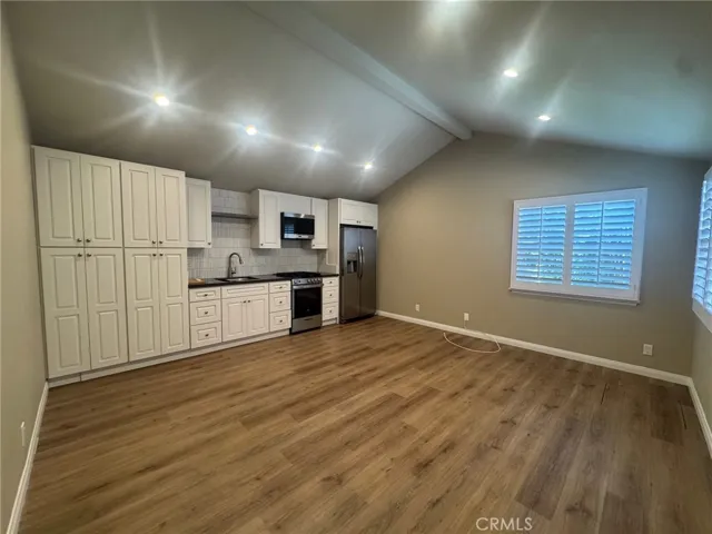 Inside, the spacious living room features high ceilings, recessed lighting, and upgraded wood flooring, creating a bright and inviting living space. The upgraded kitchen offers beautiful full-height cabinetry with abundant storage and stainless steel appliances.