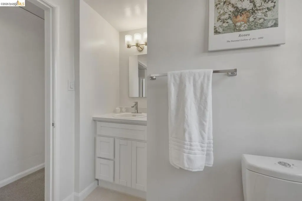 Contemporary bathroom vanity featuring a white countertop, undermount sink, and brushed nickel faucet