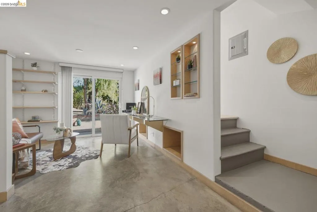 Open-concept living area with polished concrete flooring and white walls