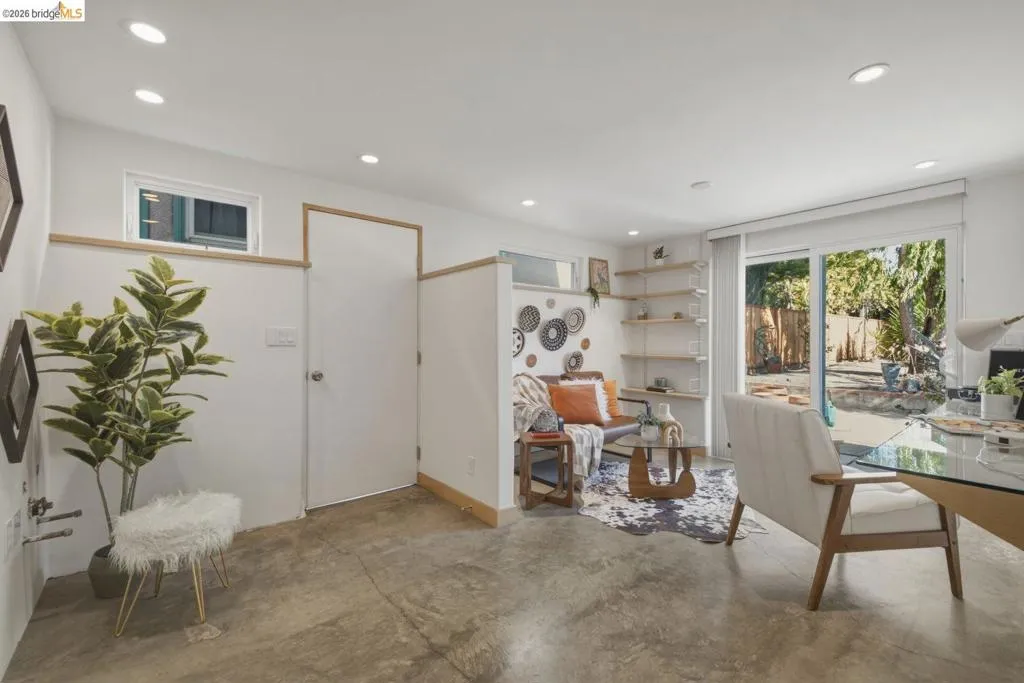 Open-concept living space featuring concrete flooring, recessed lighting, and a sliding glass door providing outdoor access