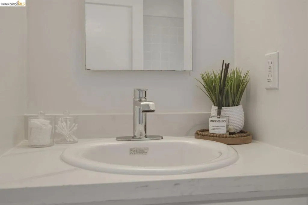 White vanity countertop with an integrated oval sink and a chrome faucet