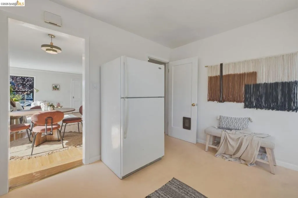 White refrigerator appliance, light-toned flooring, and a white interior door