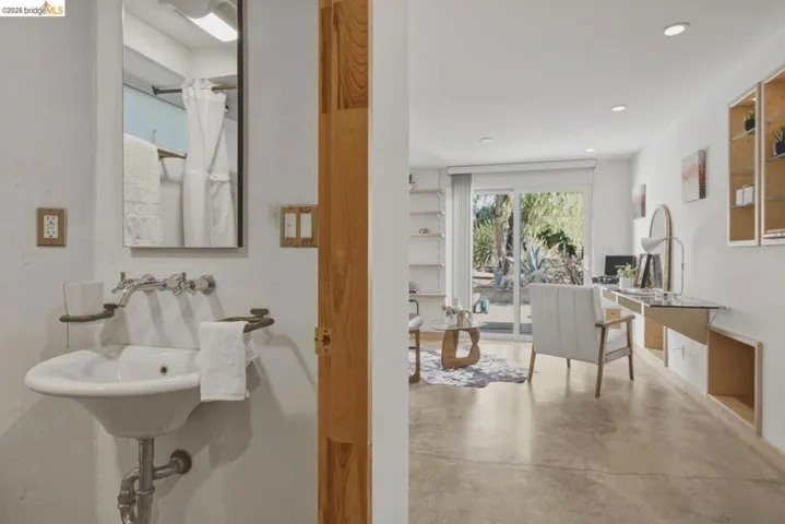 Wall-mounted basin sink with chrome fixtures and a rectangular mirror