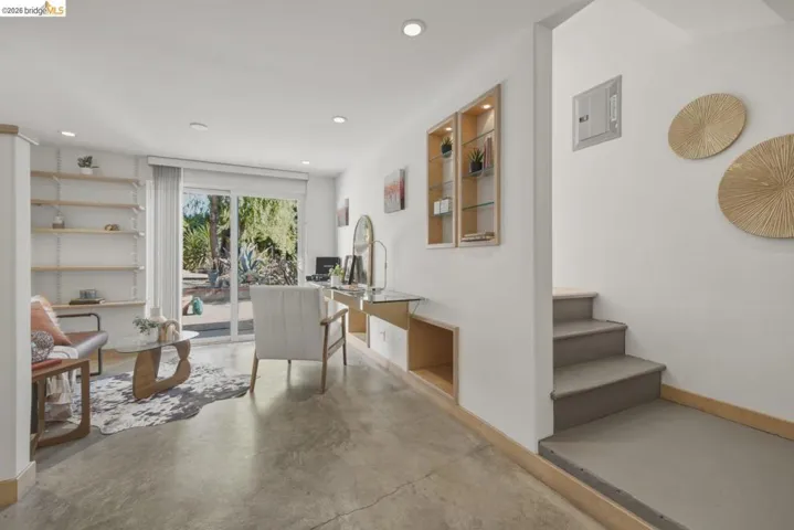 Open-concept living area with polished concrete flooring and white walls