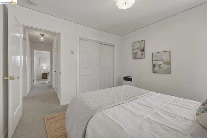 Bedroom featuring an overhead flush mount light fixture, light gray carpeting, and a built-in closet with bifold doors