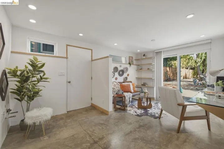 Open-concept living space featuring concrete flooring, recessed lighting, and a sliding glass door providing outdoor access