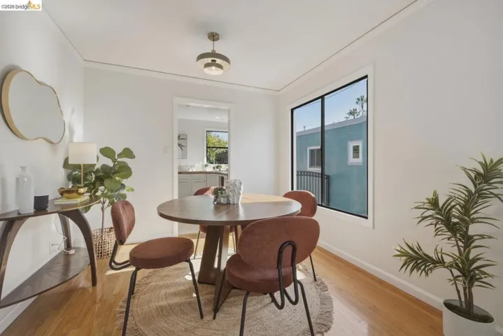 Hardwood-style flooring throughout with white baseboards and crown molding