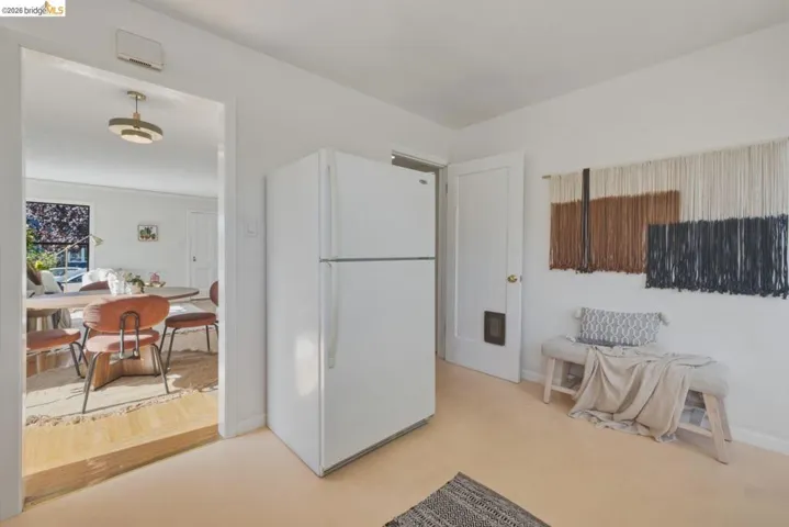 White refrigerator appliance, light-toned flooring, and a white interior door