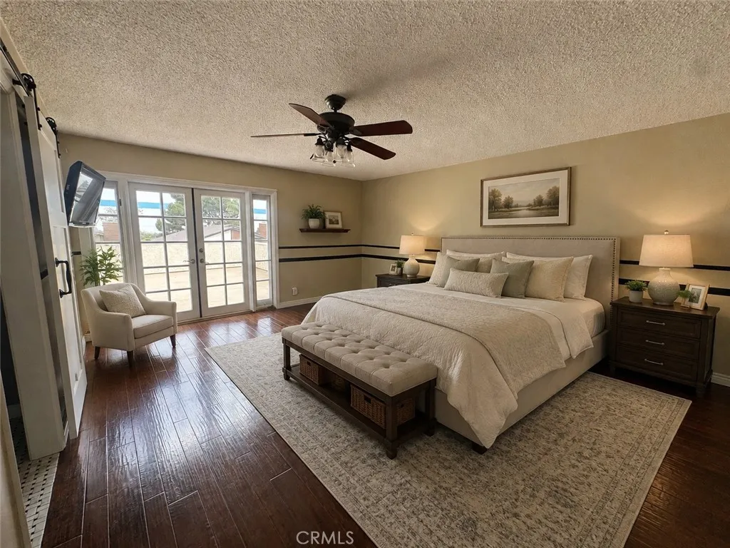Oversized primary bedroom (virtual staging) with french doors that lead to balcony Oversized primary bedroom (virtual staging) with french doors that lead to balcony