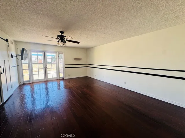 Oversized primary bedroom (virtual staging) with french doors that lead to balcony