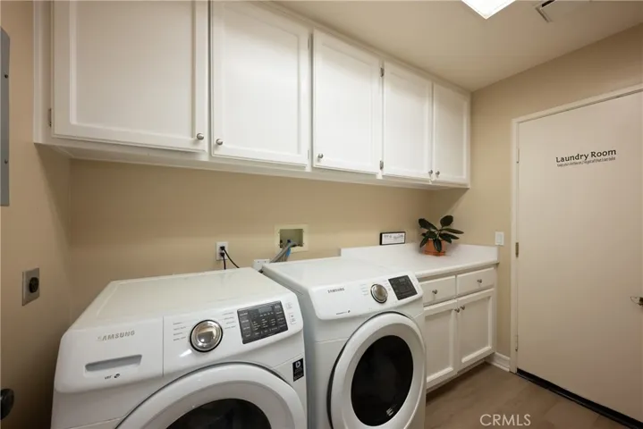 The laundry room is located downstairs with a counter for folding and white cabinets.