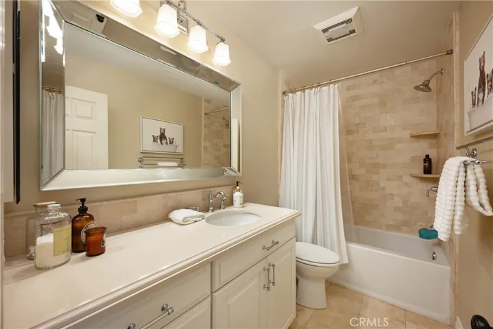 Upgraded hall bath located upstairs with Ceasarstone counter, tile flooring and travertine wainscotting.