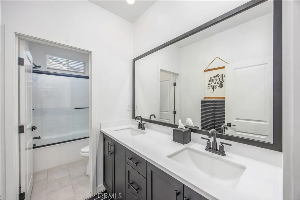 Secondary bathroom features dual sinks, generous counter space, and a tub/shower combination