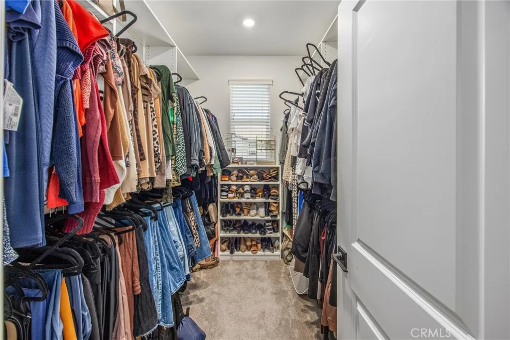 Spacious walk-in closet with generous hanging and storage space