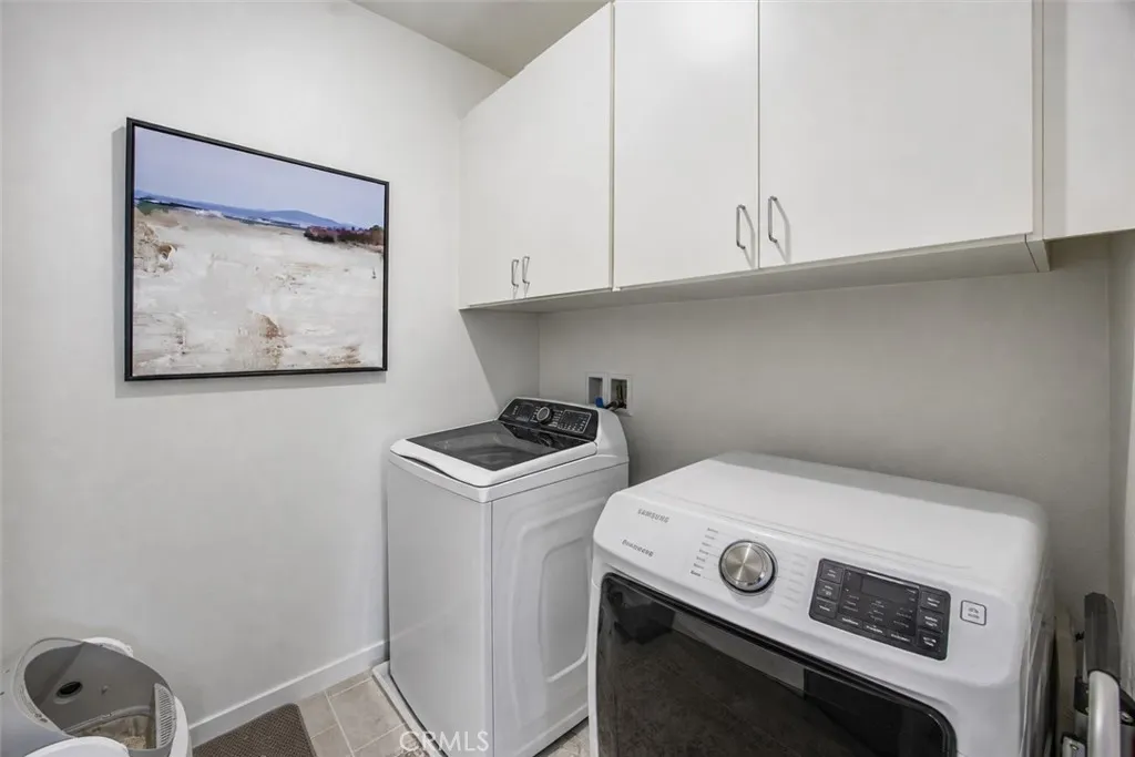 Convenient upstairs laundry room with built-in cabinetry for added storage