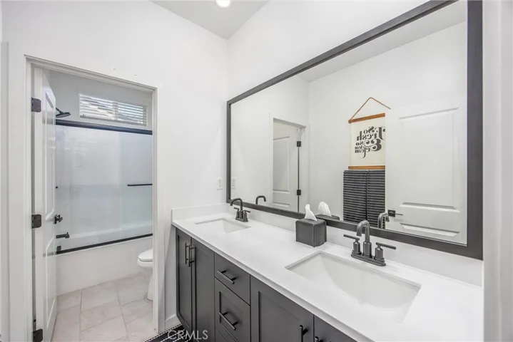 Secondary bathroom features dual sinks, generous counter space, and a tub/shower combination