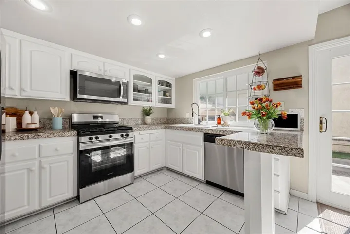 Kitchen-Gas range, newer dishwasher, counter seating, window to rear yard, tile flooring.